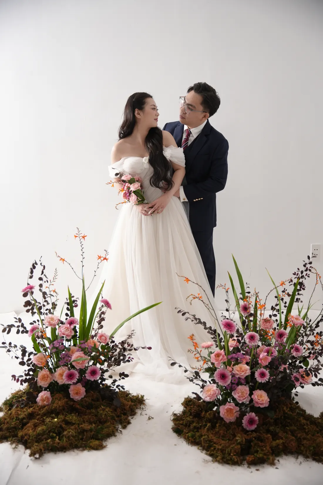 Hai người ôm nhau giữa hai bình hoa